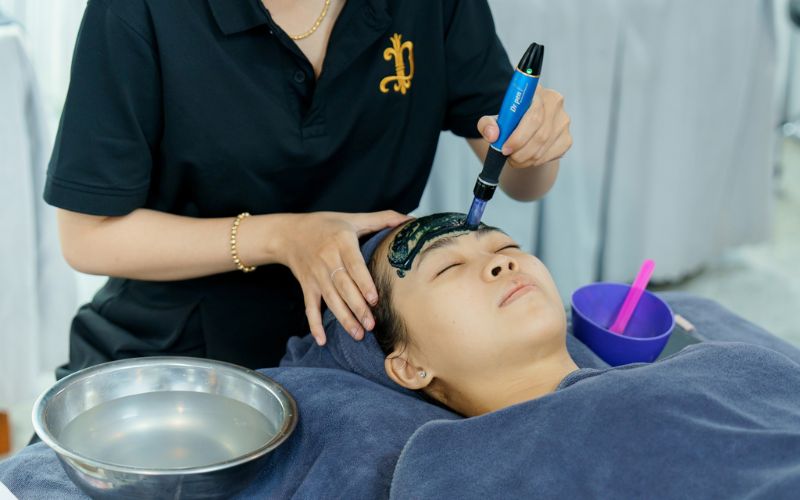 Chuyên viên spa đang thực hiện liệu trình vi kim tảo cho khách hàng